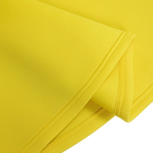 Detailed close-up of double-needle stitching and overlock seams on yellow dress fabric