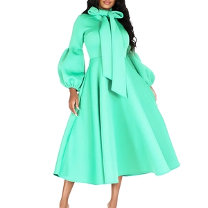 Detail of mint green long sleeve dress with puff sleeves and elegant bow tie neckline