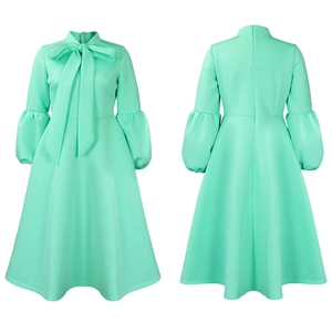 Detail view of mint green plus size dress with lantern sleeves and a large bow neckline
