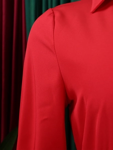 Detailed close-up of neckline and shoulder on a red dress with fine twill texture