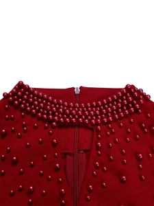 Close-up of red high-neck dress featuring elegant pearl beadwork and hollow-out chest detail