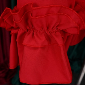 Detailed macro view of red ruffled cuffs with elastic shirring on the flowy dress