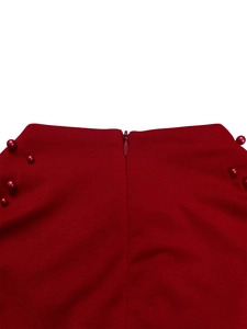 Detail of burgundy dress waist featuring invisible zipper and symmetric bead embellishments