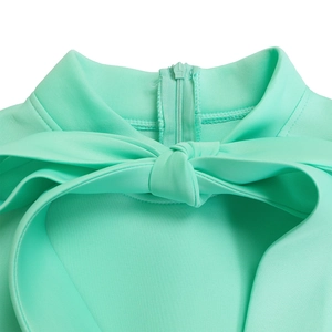 Detail of mint green puff sleeve dress featuring a high collar and oversized bow decoration