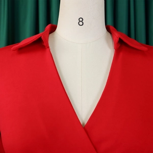 Detailansicht des roten V-Ausschnitts mit Kragen an einem eleganten Kleid aus Strukturstoff