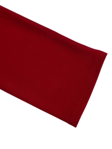 Detailed close-up of double-needle stitching on dark red dress sleeves and knit fabric