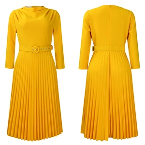 Detail of yellow pleated dress featuring elegant accordion folds and waist belt with buckle