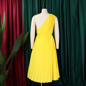 Detail view of the pleated yellow one-shoulder dress back with draping fabric