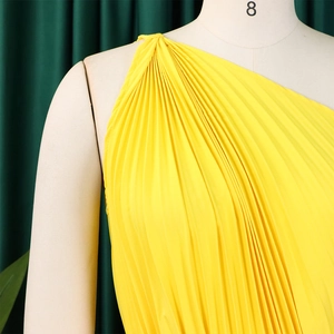 Detail of bright yellow one-shoulder pleated dress with high-quality textured fabric