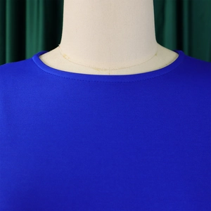 Detailed view of the simple crew neck and pleated knit fabric on this elegant blue dress