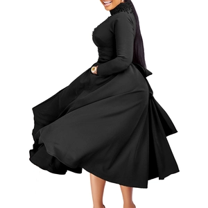 Detail of high neck black gown with intricate pearl beading and flared skirt silhouette