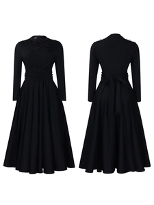 Detail of high neck beading and pleated waist on an elegant black A-line dress