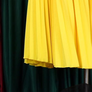 Detail of bright yellow pleated fabric showing vertical pleats and chiffon texture