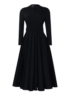 Detailed view of hand-beaded neckline and ruched waist on a black long-sleeve gown