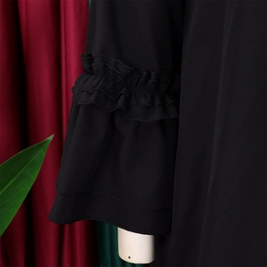 Detailed view of elegant black tiered ruffle bell sleeves on a plus size dress
