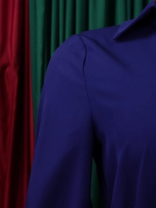 Close-up of the lapel collar and shoulder stitching on a navy long-sleeve dress