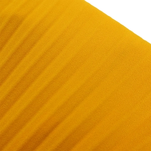 Macro shot of bright yellow pleated chiffon fabric with detailed vertical texture