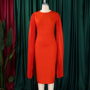 Detail of elegant red party dress featuring pleated cape sleeves and a slim fit waist