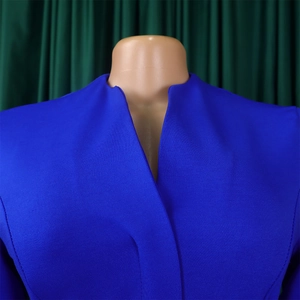 Détail de la robe bleu roi montrant le col montant minimaliste et le tissu texturé