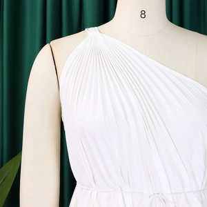 Close-up of white one-shoulder pleated dress with waist tie on a professional mannequin