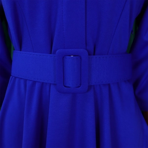 Gros plan sur le tissu plissé bleu roi de la robe avec ceinture assortie et boucle carrée