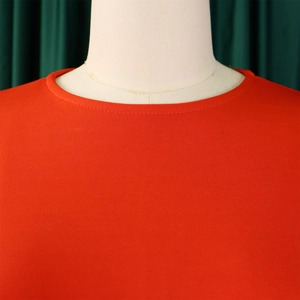 Close-up of elegant red long sleeve dress showing fine fabric texture and neckline stitching