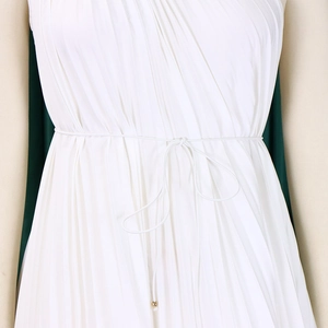 Detailed view of white pleated dress fabric with a waist tie cord and gold beads
