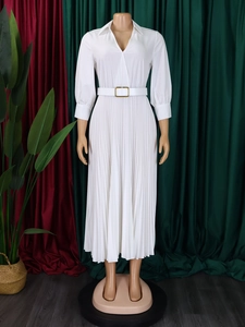 Close-up of white long sleeve pleated dress with gold buckle belt and V-neckline detail