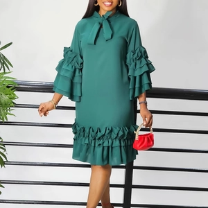 Detail of dark green dress with tiered ruffle sleeves and a bow neckline detail