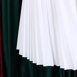 Detail of high-density pleated white fabric with crisp vertical lines and wavy hemline