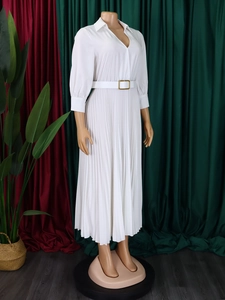 Detail of white pleated dress showing the lapel V-neckline and waist belt with gold buckle
