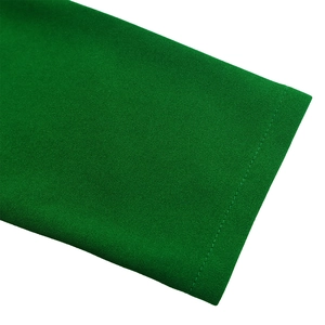 Detail of green pleated dress fabric showing high-quality crepe texture and precise stitching
