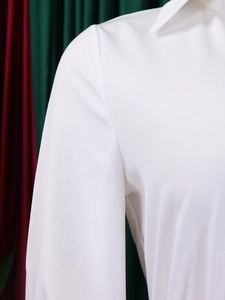 Detail view of white shirt collar and shoulder seams with premium pleated texture