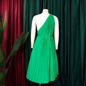 Detail of bright green one-shoulder pleated midi dress showing textured fabric on mannequin