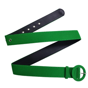 Detail of green suede belt with round fabric-covered buckle and silver metal grommets