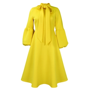 Detailed view of yellow lantern sleeves and elegant bow neckline on a social party dress