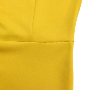 Close-up of high-quality stitching and textured yellow knit fabric on a long sleeve dress