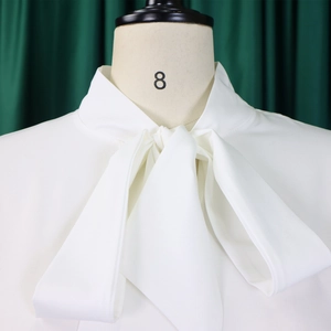 Dettaglio di elegante camicetta bianca in chiffon con grande fiocco sulla scollatura