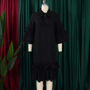 Detailed view of ruffle flare sleeves and tie-up bow neckline on a black summer dress