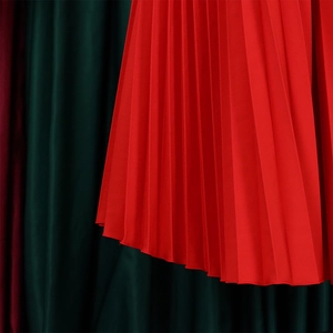 Macro shot of vibrant red pleated fabric with fine silk luster and sharp vertical folds