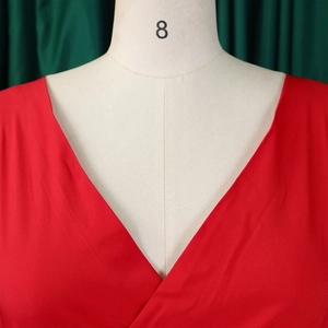 Detail of red V-neck blouse with crossover straps and smooth textured fabric finish