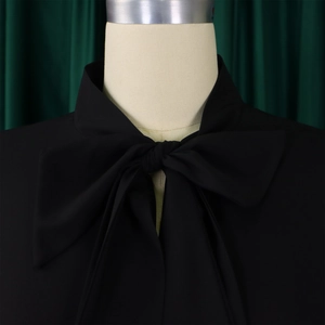 Detail of elegant black dress with a tie-up bow neckline and ruffled sleeves design