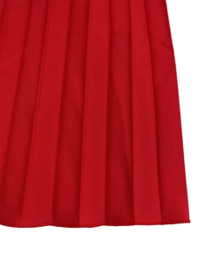 Close-up of bright red pleated skirt fabric texture with fine stitched hemline detail