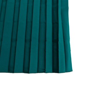 Detailed view of dark green pleated fabric featuring fine stitching and subtle luster