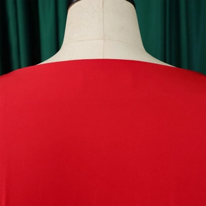 Detail view of the elegant square neckline and smooth red fabric of the puff sleeve blouse