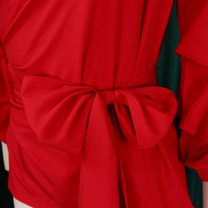 Close-up of a red V-neck blouse featuring an elegant waist tie with a large bow detail