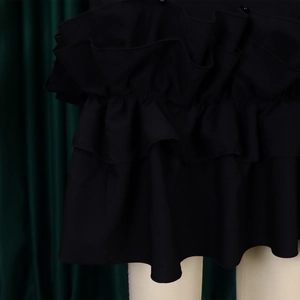 Close-up of elegant ruffled layers and textured fabric on a black summer dress