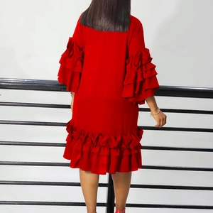 Rear view of a red dress featuring tiered ruffle sleeves and a flowing layered hemline