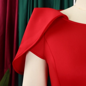 Détail d'une robe rouge élégante avec épaule plissée et tissu drapé structuré