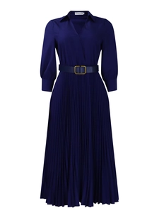 Detail of navy blue pleated dress featuring V-neck, golden buckle belt and lantern sleeves